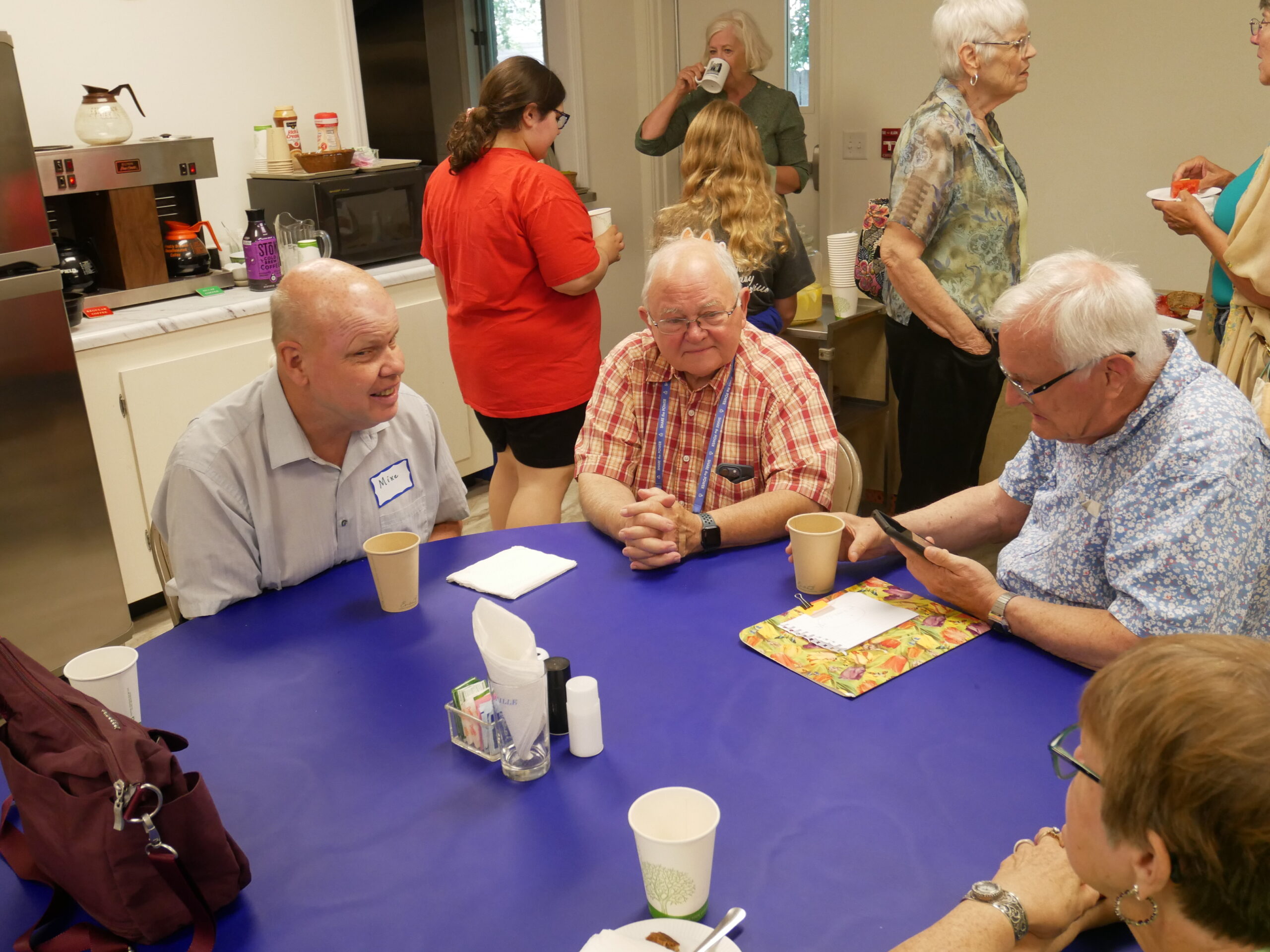 a group of men sitting around a table talking