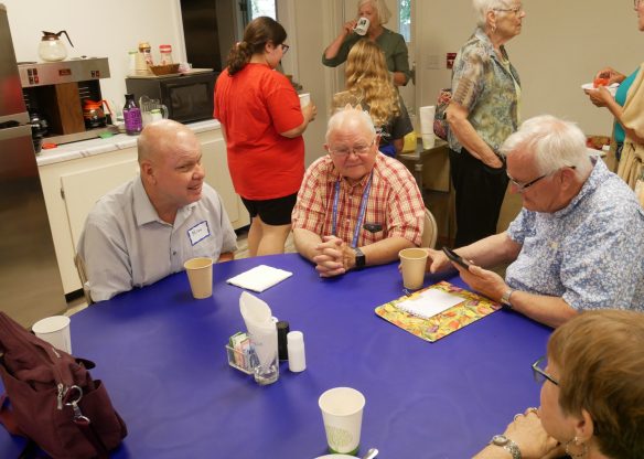 a group of men sitting around a table talking